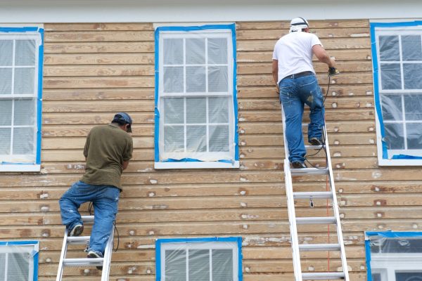 two-workers-working-together-to-strip-paint-from-h-2026-01-11-09-23-31-utc